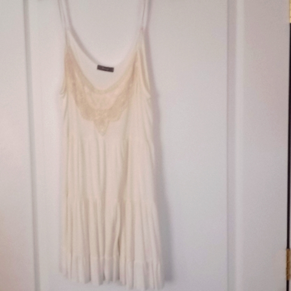Cream colored camisole shirt with detailed pattern.